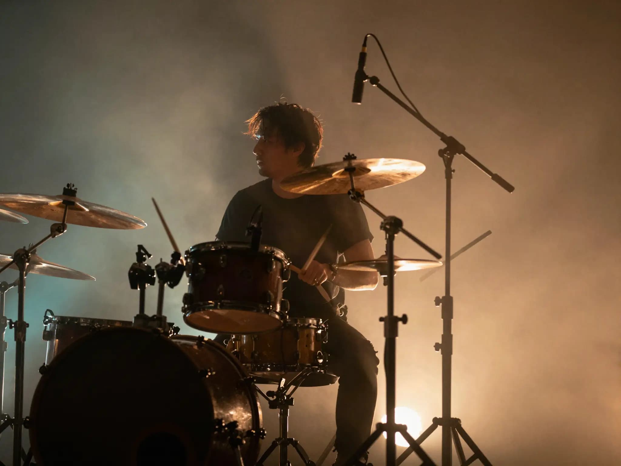 Drummer silhouette in amber stage backlight