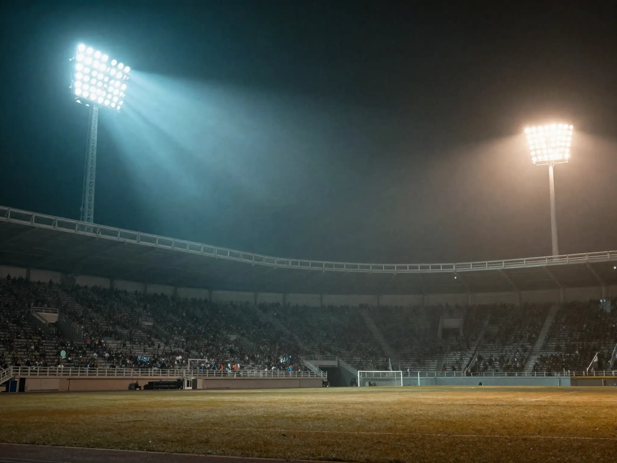Stadium floodlights glowing over a packed night crowd